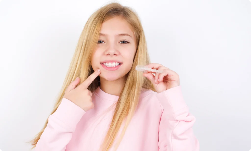 Adolescente souriante tenant une gouttière transparente
