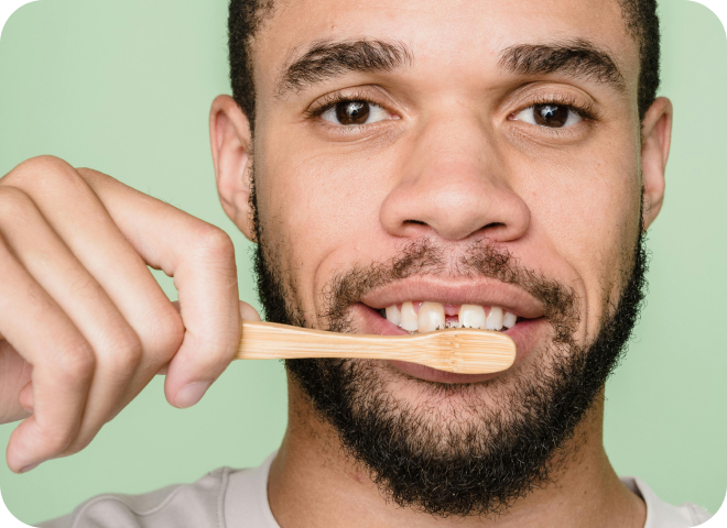 Homme se brossant les dents avec une brosse en bambou