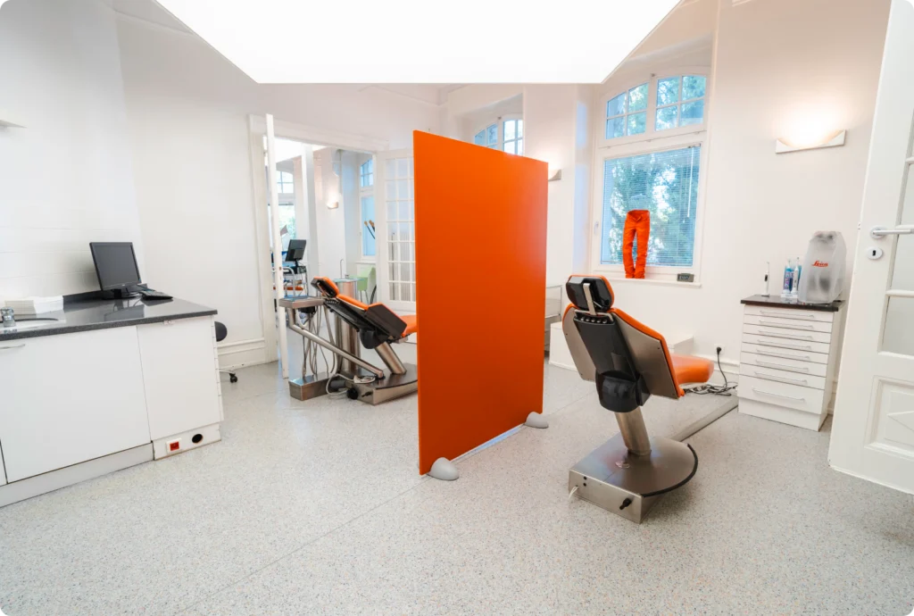 Salle de soin avec cloison orange et fauteuil dentaire