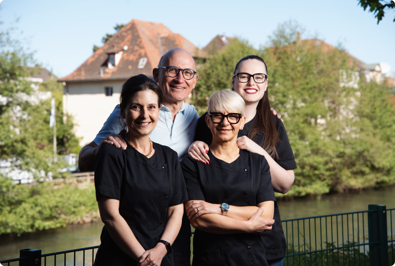 Famille de patients souriante en extérieur près du cabinet