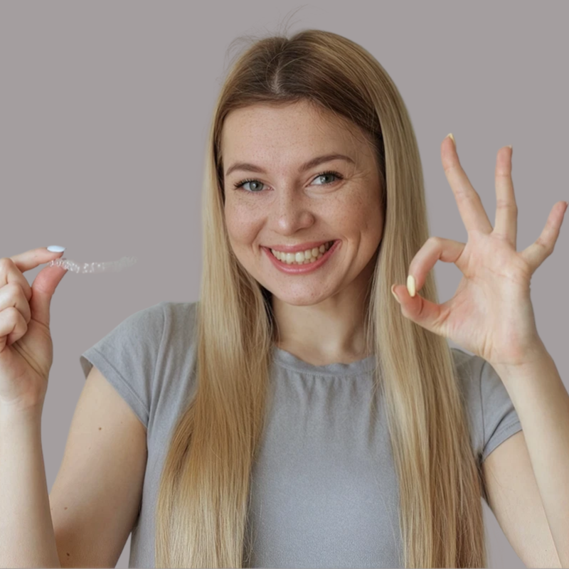 Jeune femme faisant un signe pouce levé avec des bagues dentaires