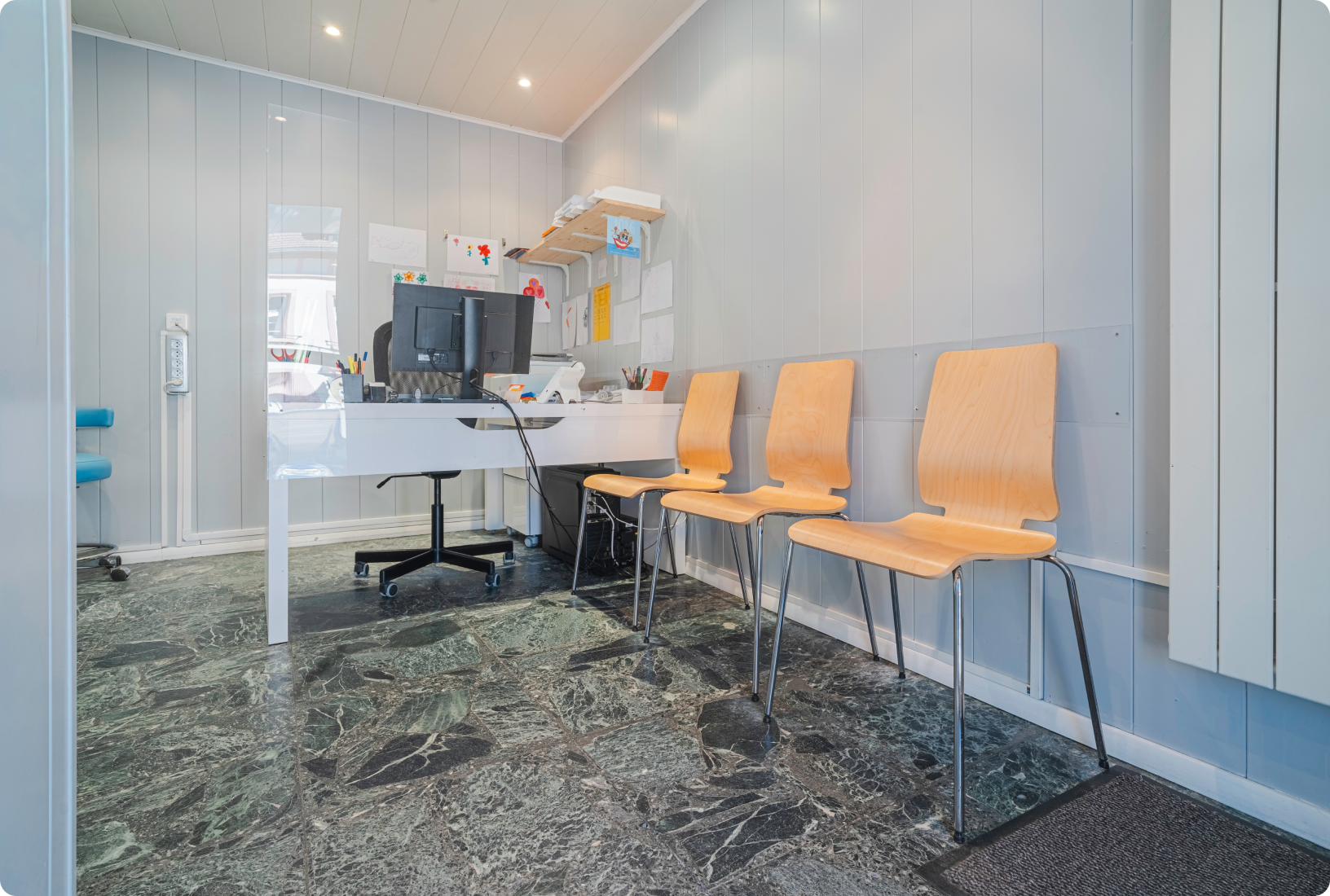 Salle d'attente du cabinet avec fauteuils orange